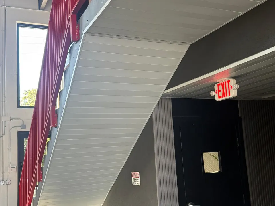 Metal wall panels fitted below exit stair