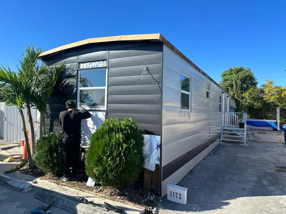 Mobile home transformed with dark horizontal metal siding