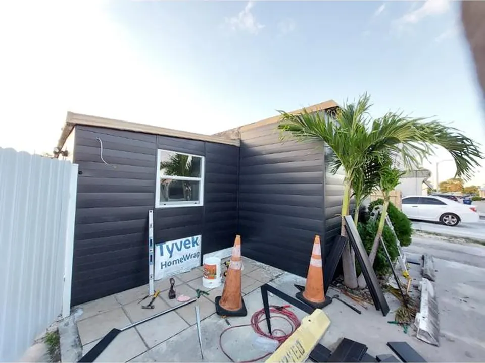 Rear wall finished with dark horizontal metal siding